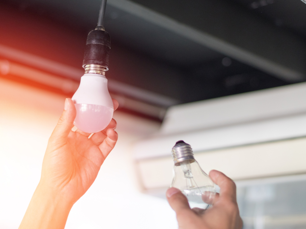 a hand replacing a lightbulb