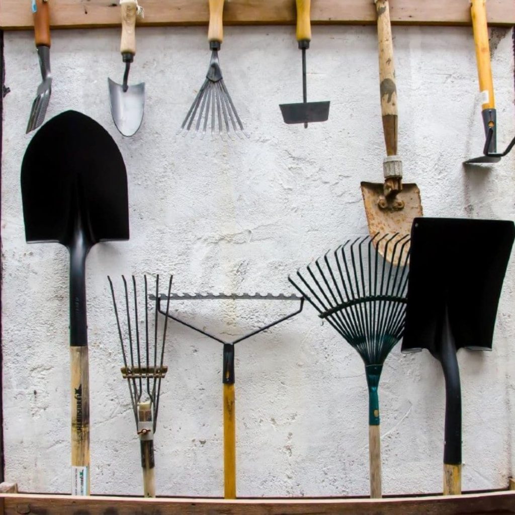 garden tools on a wall in a garage to be stored away