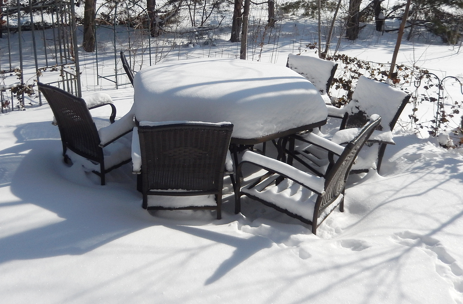 A set of outdoor table and chairs covered in snow.
