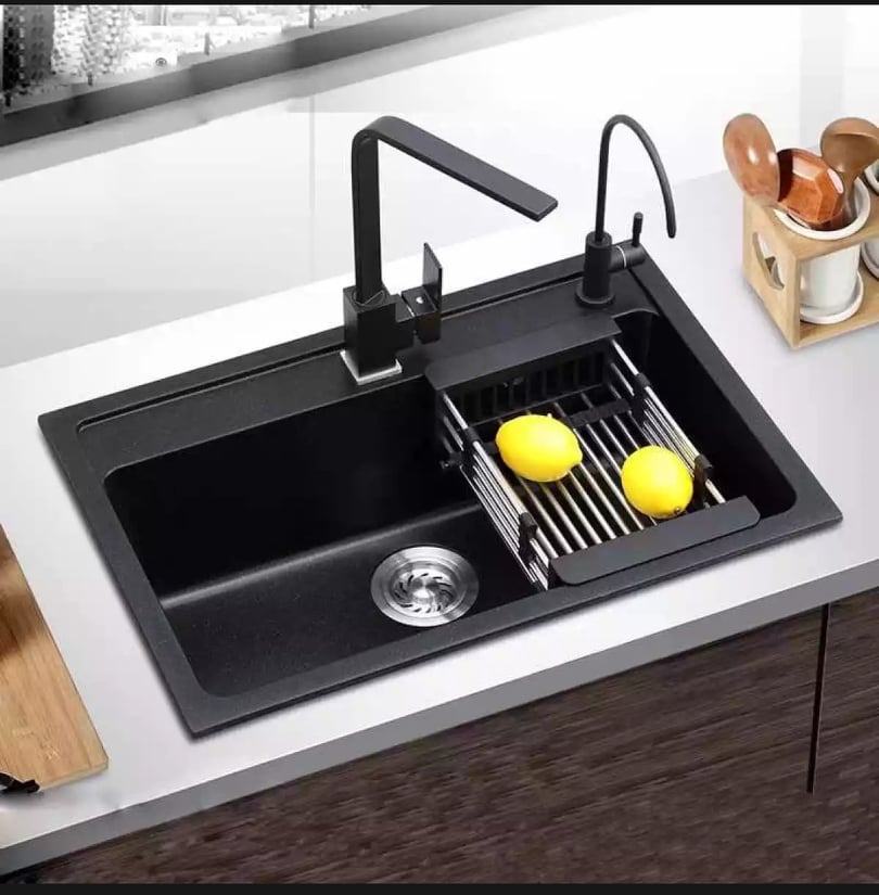 A black kitchen sink with tray and 2 lemon on it to remove the odor and freshen up as guided in our  February Home Maintenance Tips